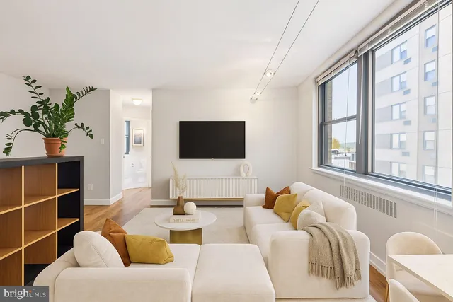 a living room with furniture a flat screen tv and a window