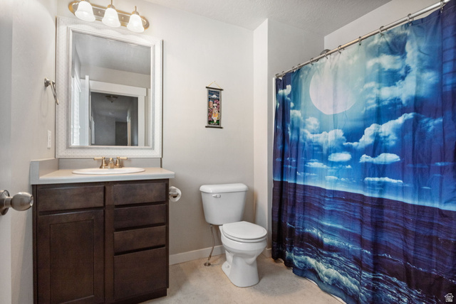 5155 East Rio Grande Way Eagle Mountain, UT 84005 - Photo 28 of 40 Full bathroom with vanity, a shower with shower curtain, and a textured ceiling