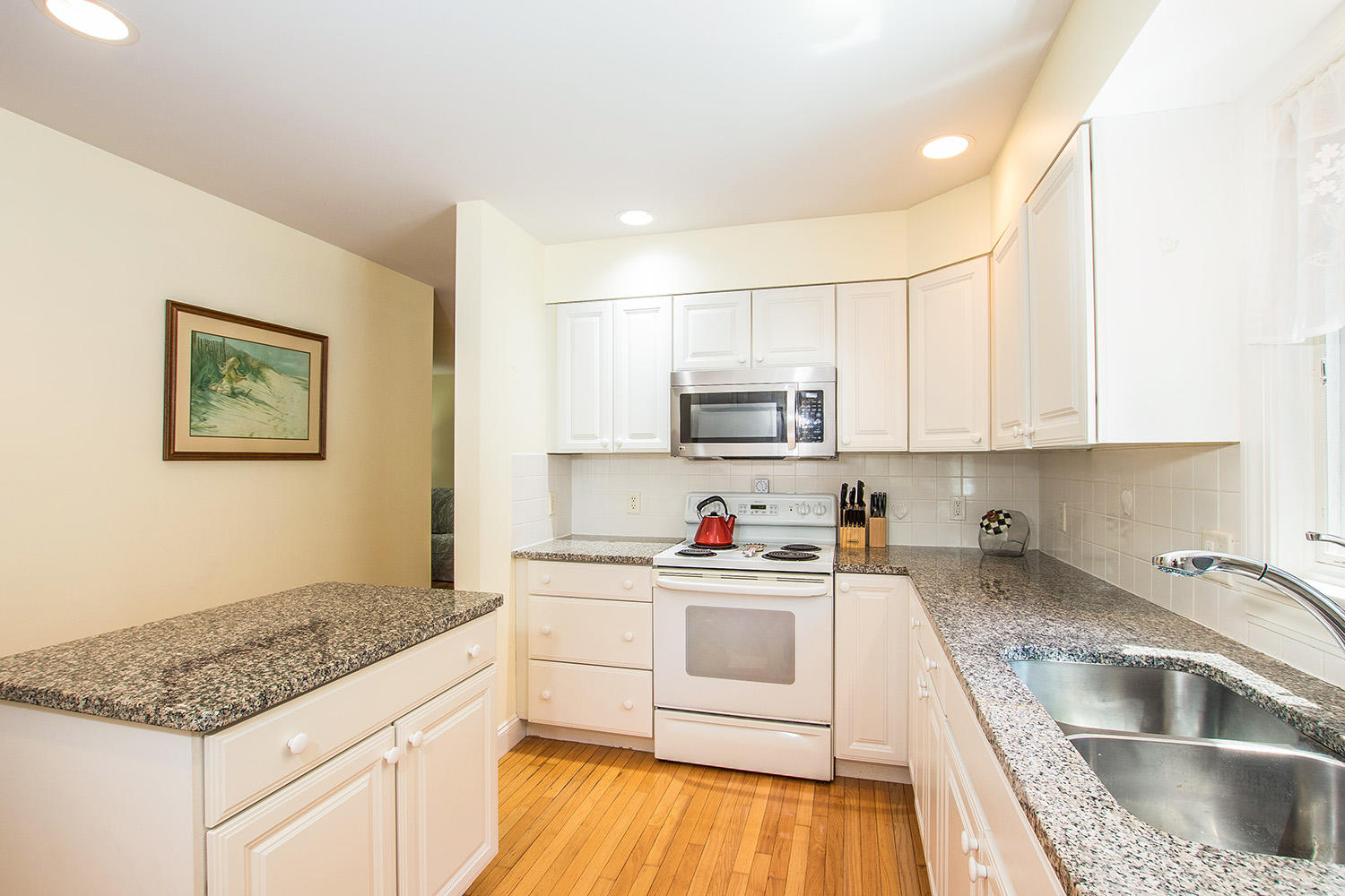 466 Training Field Road Chatham, MA 02633 - Photo 8 of 25 a kitchen with stainless steel appliances granite countertop a sink dishwasher a stove and white cabinets with wooden floor