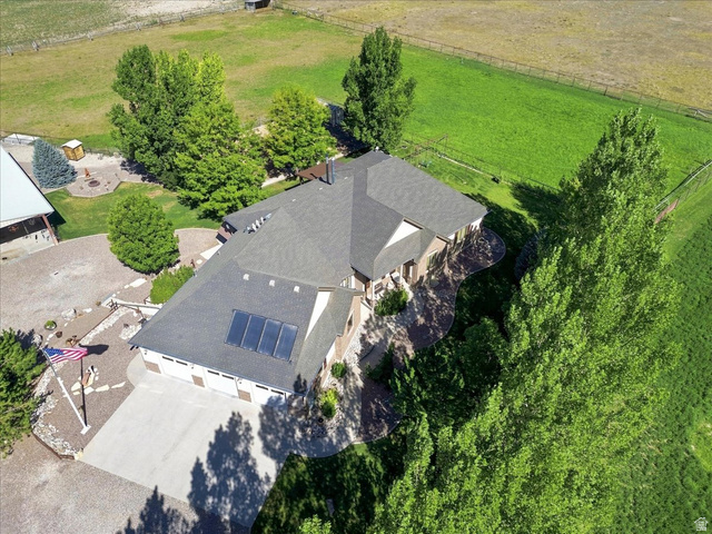 11290 South Southfield Road Mayfield, UT 84643 - Photo 14 of 103 Shingle roof, attached multi-car garage, solar panels, expansive green spaces, and surrounding trees