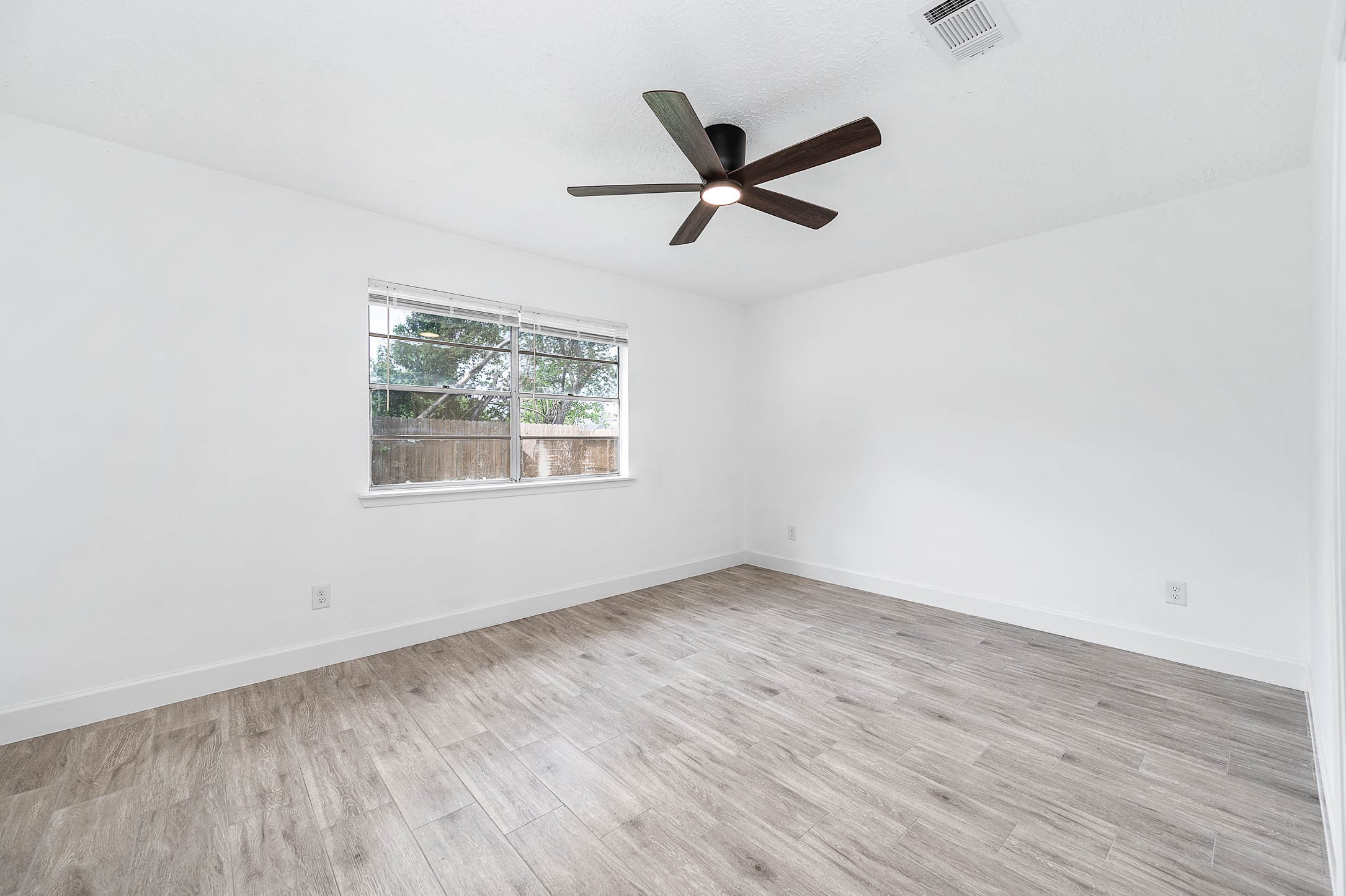 10402 Rancho Bernardo Lane Sugar Land, TX 77498 - Photo 19 of 30 a view of empty room with wooden floor and fan