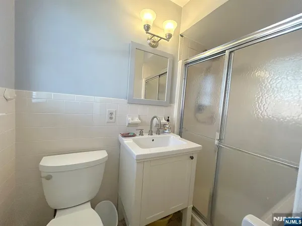 a kitchen with stainless steel appliances granite countertop a refrigerator a stove a sink dishwasher and white cabinets with wooden floor