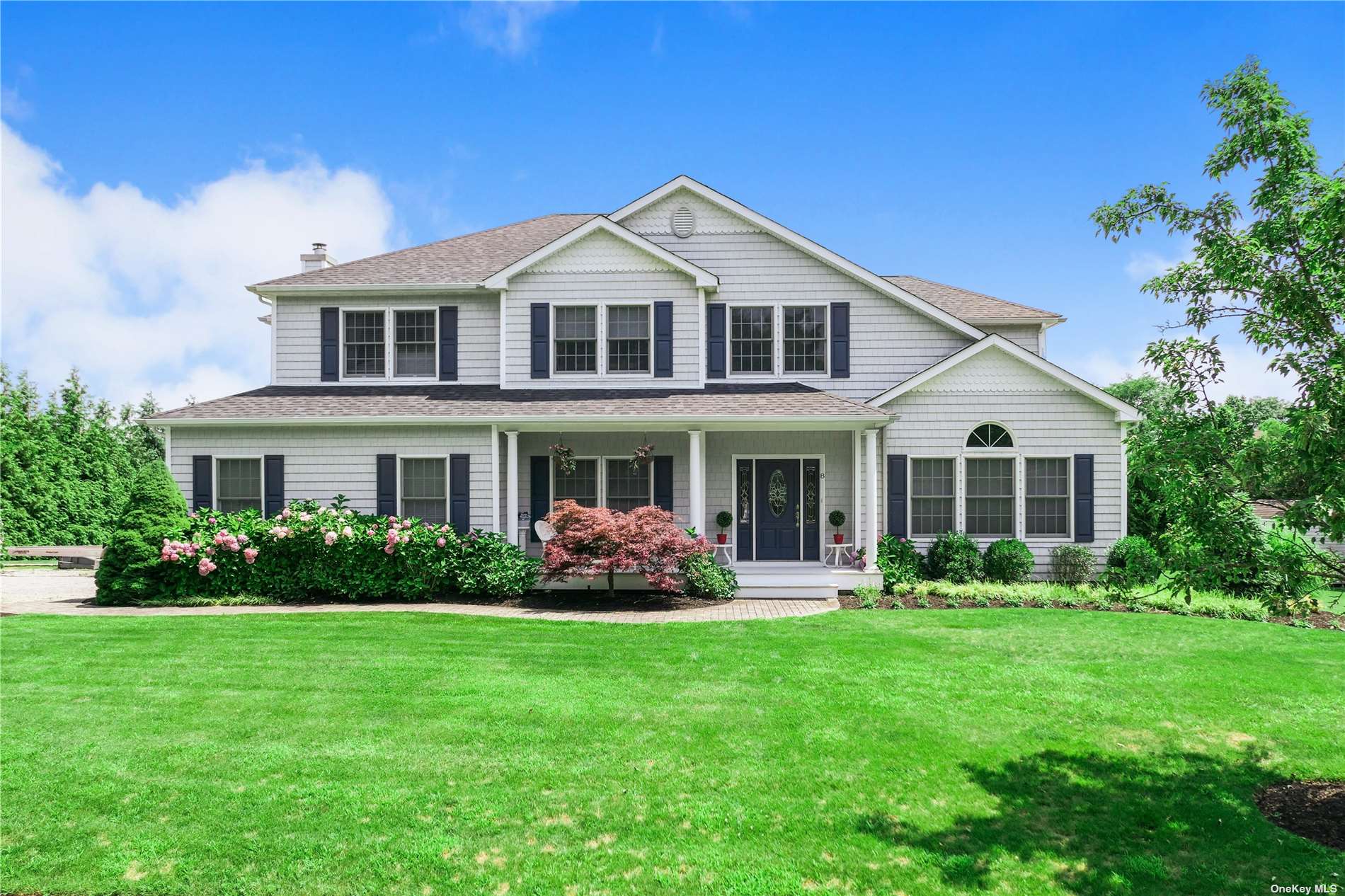 a front view of a house with a garden and plants