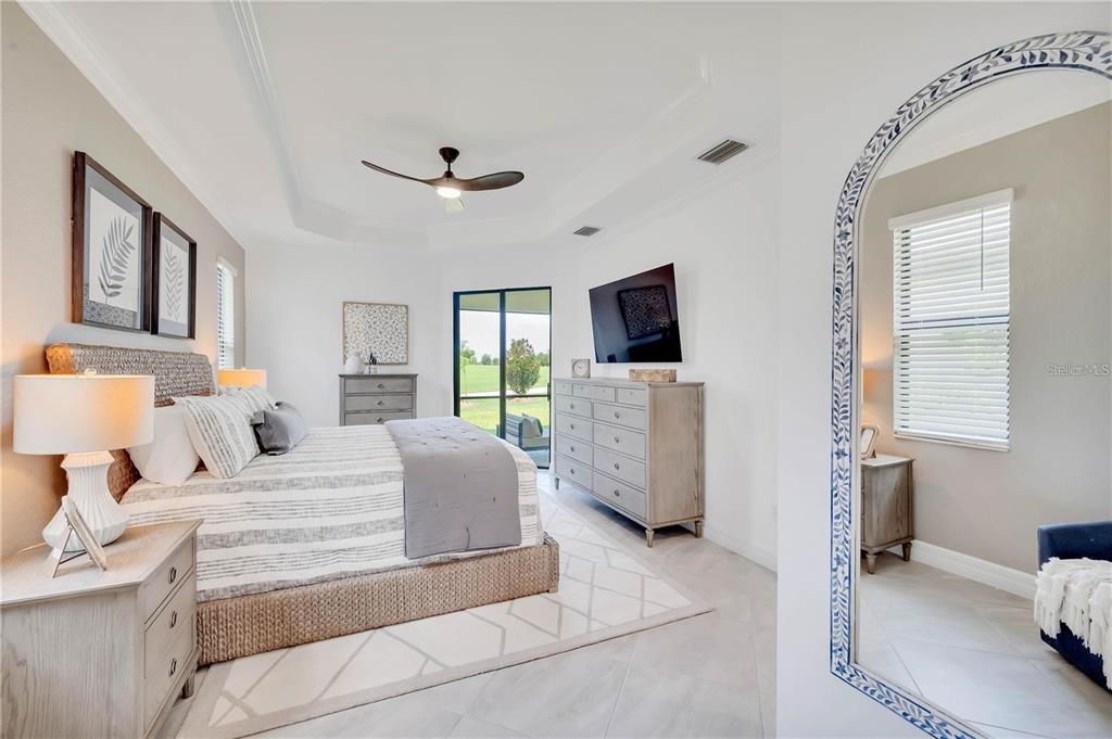 5822 Brandon Run Bradenton, FL 34211 - Photo 24 of 34 a bedroom with a bed flat screen tv and couches