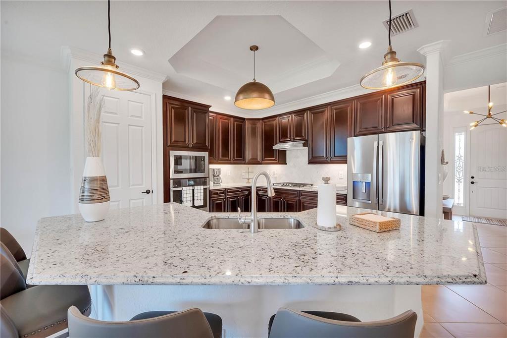 5822 Brandon Run Bradenton, FL 34211 - Photo 7 of 34 a kitchen with stainless steel appliances granite countertop a sink a stove a refrigerator cabinets and chairs