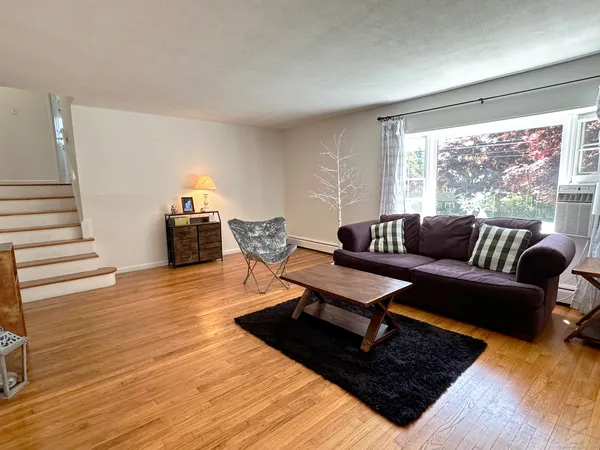 a living room with furniture and a wooden floor