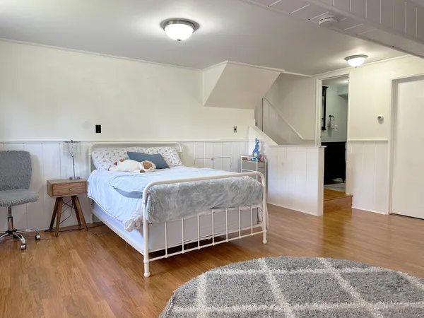 a bedroom with a bed and wooden floor