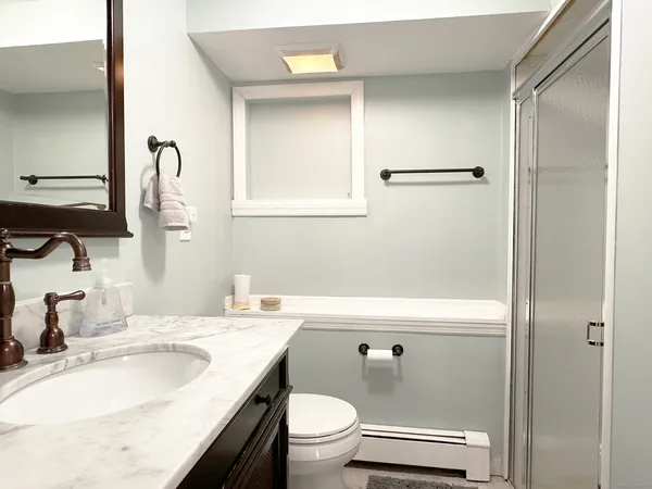 a bathroom with a granite countertop sink toilet and shower