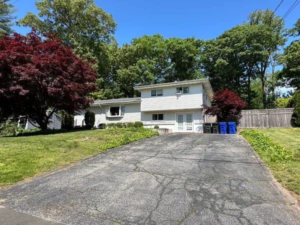 a view of a house with a yard and large trees