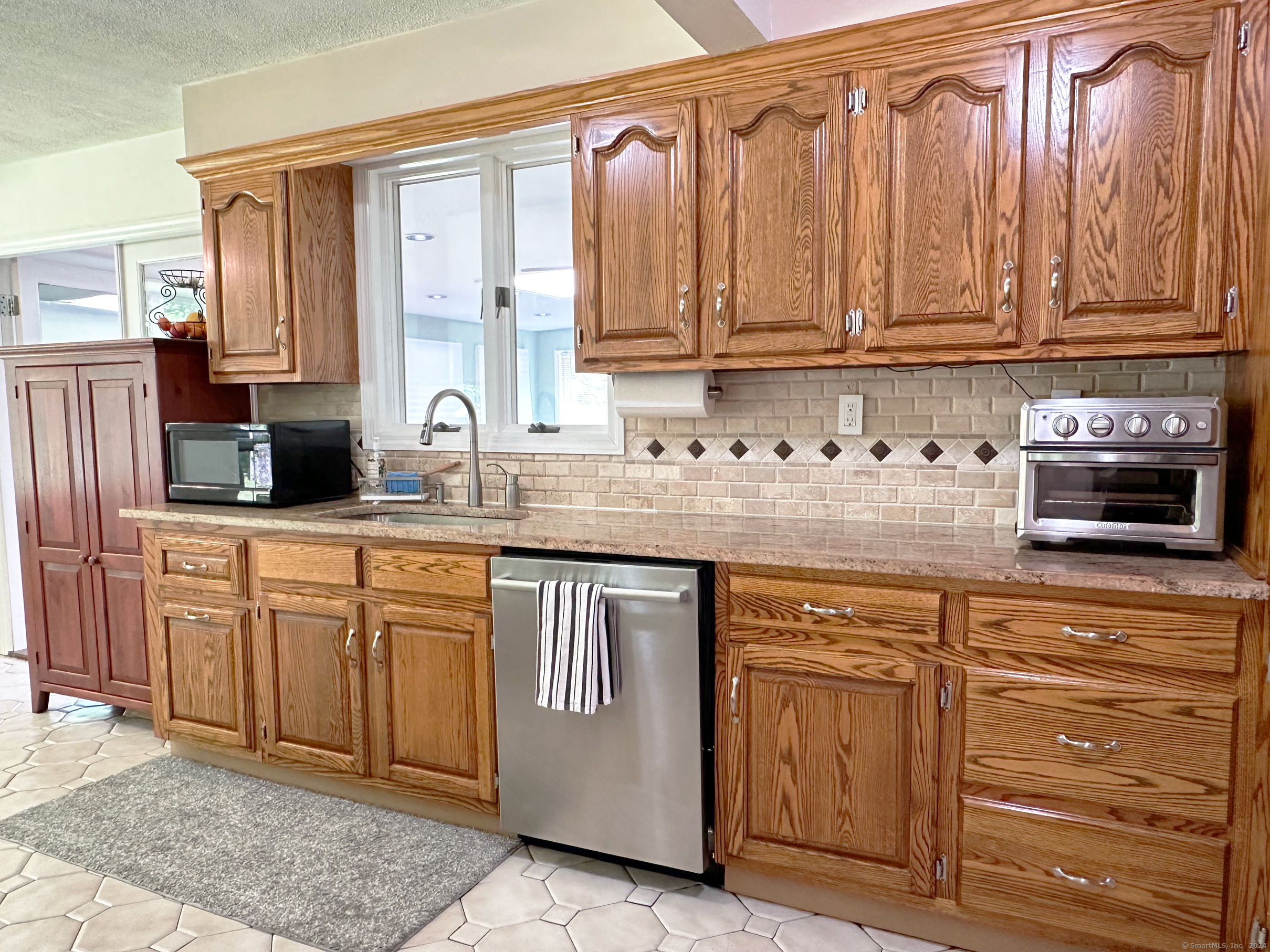 39 Mohawk Drive Norwalk, CT 06851 - Photo 10 of 37 a kitchen with stainless steel appliances granite countertop a sink and cabinets with wooden floor