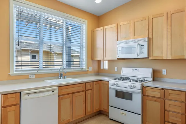 a kitchen with stainless steel appliances granite countertop a sink a stove and cabinets
