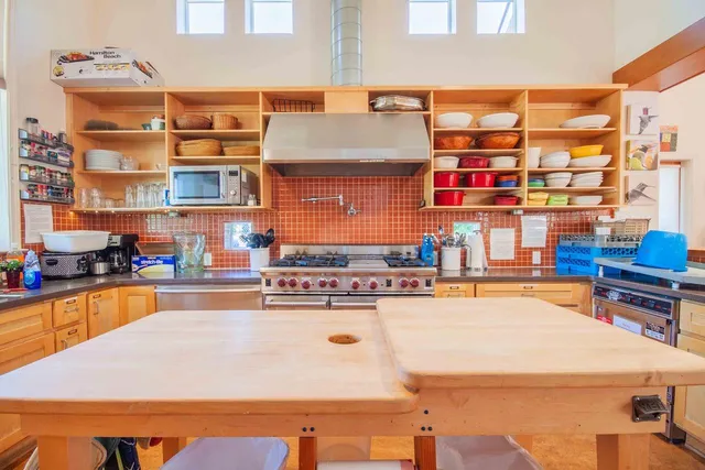 a living room with furniture and a dining table with wooden floor