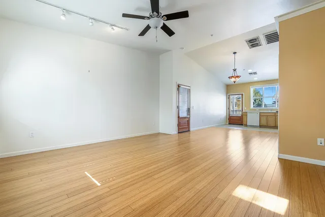 a view of empty room with wooden floor and windows