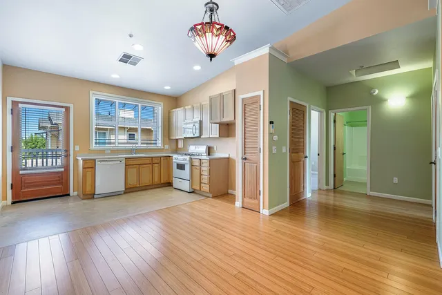 a view of a kitchen with a fridge wooden floor and a kitchen