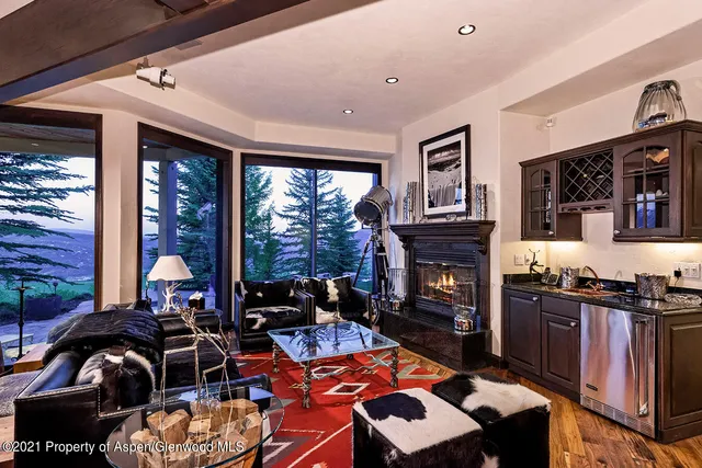 a living room with fireplace furniture and a floor to ceiling window