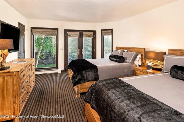 a bedroom with two beds and a large window