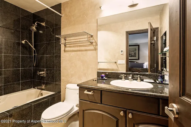 a bathroom with a sink a toilet a mirror and bathtub
