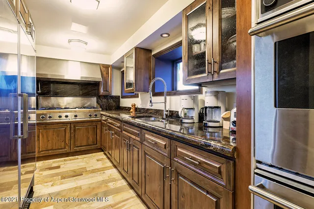 a kitchen with stainless steel appliances granite countertop a refrigerator and a stove top oven