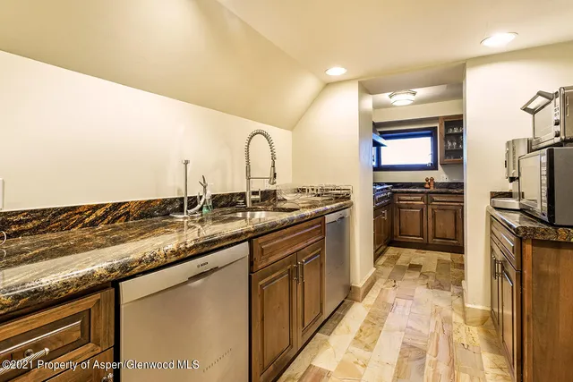 a kitchen with granite countertop a sink stainless steel appliances and cabinets