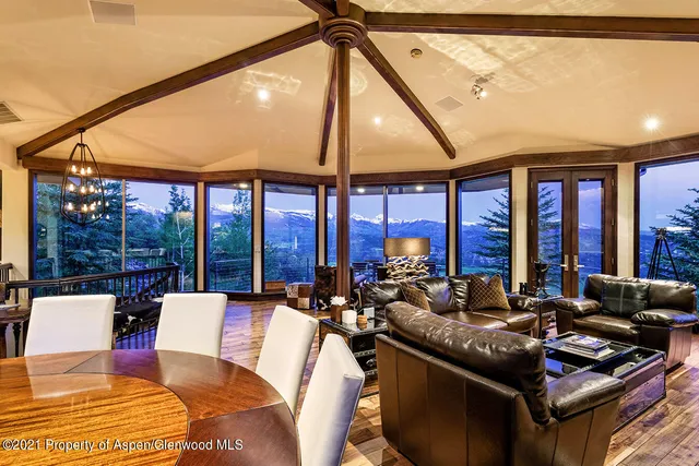 a living room with furniture and floor to ceiling windows