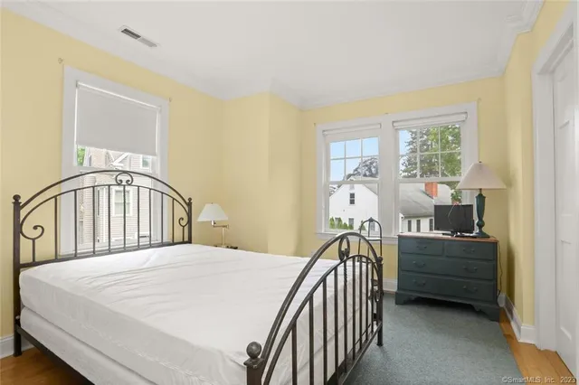 a bedroom with a bed next to a window