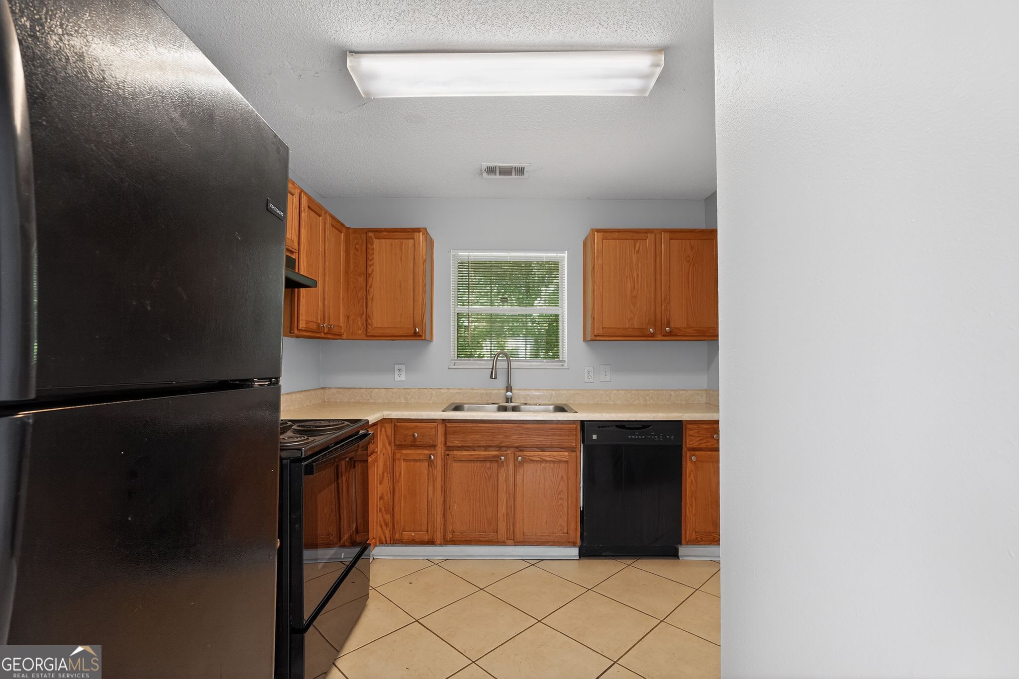 2404 Raven Circle Lithonia, GA 30058 - Photo 16 of 38 a kitchen with stainless steel appliances granite countertop a refrigerator and a sink