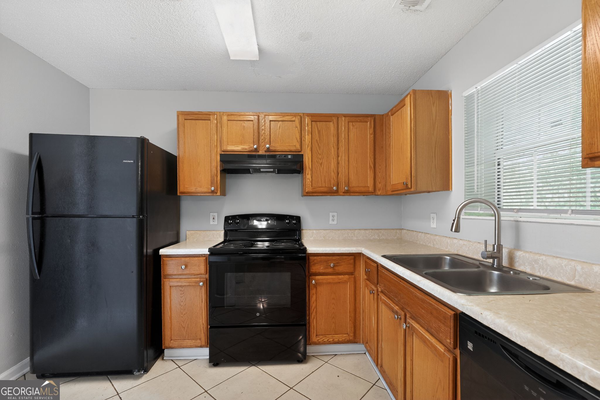 2404 Raven Circle Lithonia, GA 30058 - Photo 17 of 38 a kitchen with a sink and a refrigerator