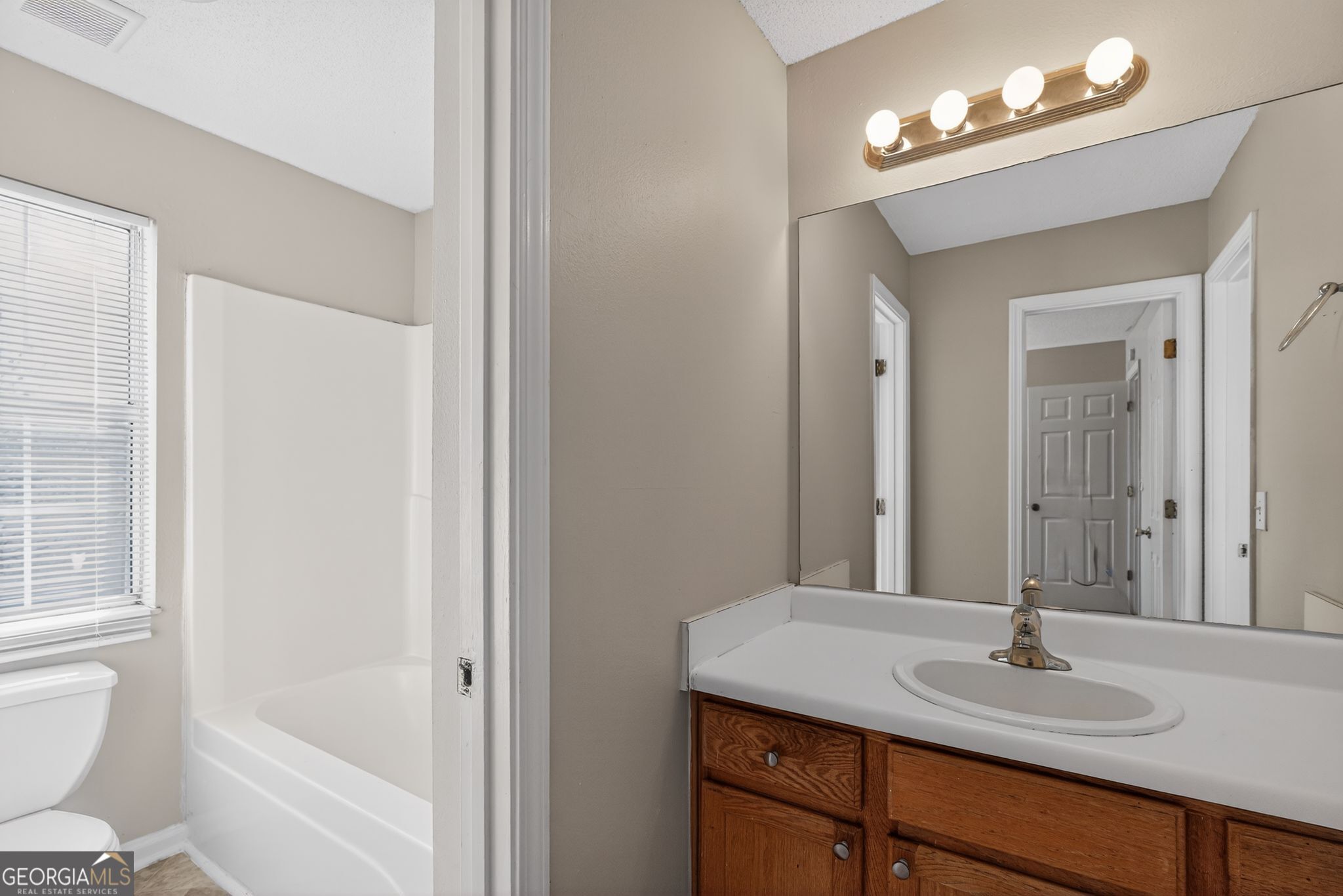 2404 Raven Circle Lithonia, GA 30058 - Photo 27 of 38 a bathroom with a sink a toilet and a mirror