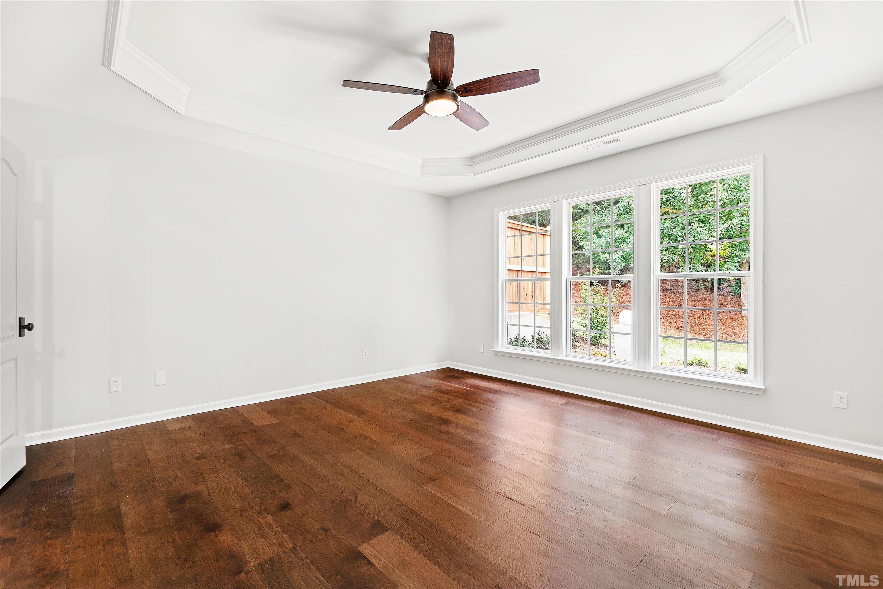 4618 Manassa Pope Lane Raleigh, NC 27612 - Photo 19 of 45 an empty room with wooden floor fan and windows