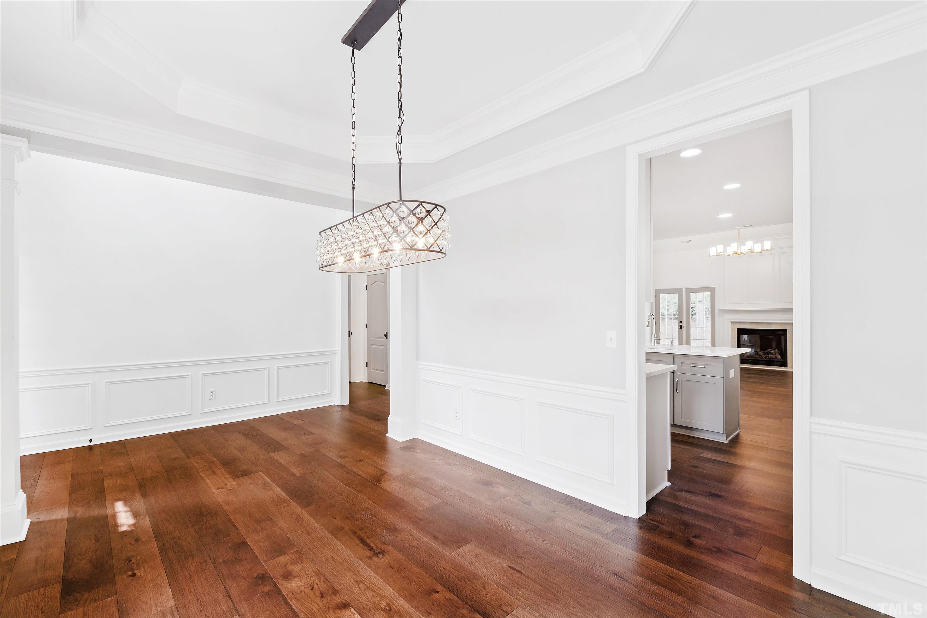 4618 Manassa Pope Lane Raleigh, NC 27612 - Photo 7 of 45 a view of a hallway with wooden floor and a chandelier