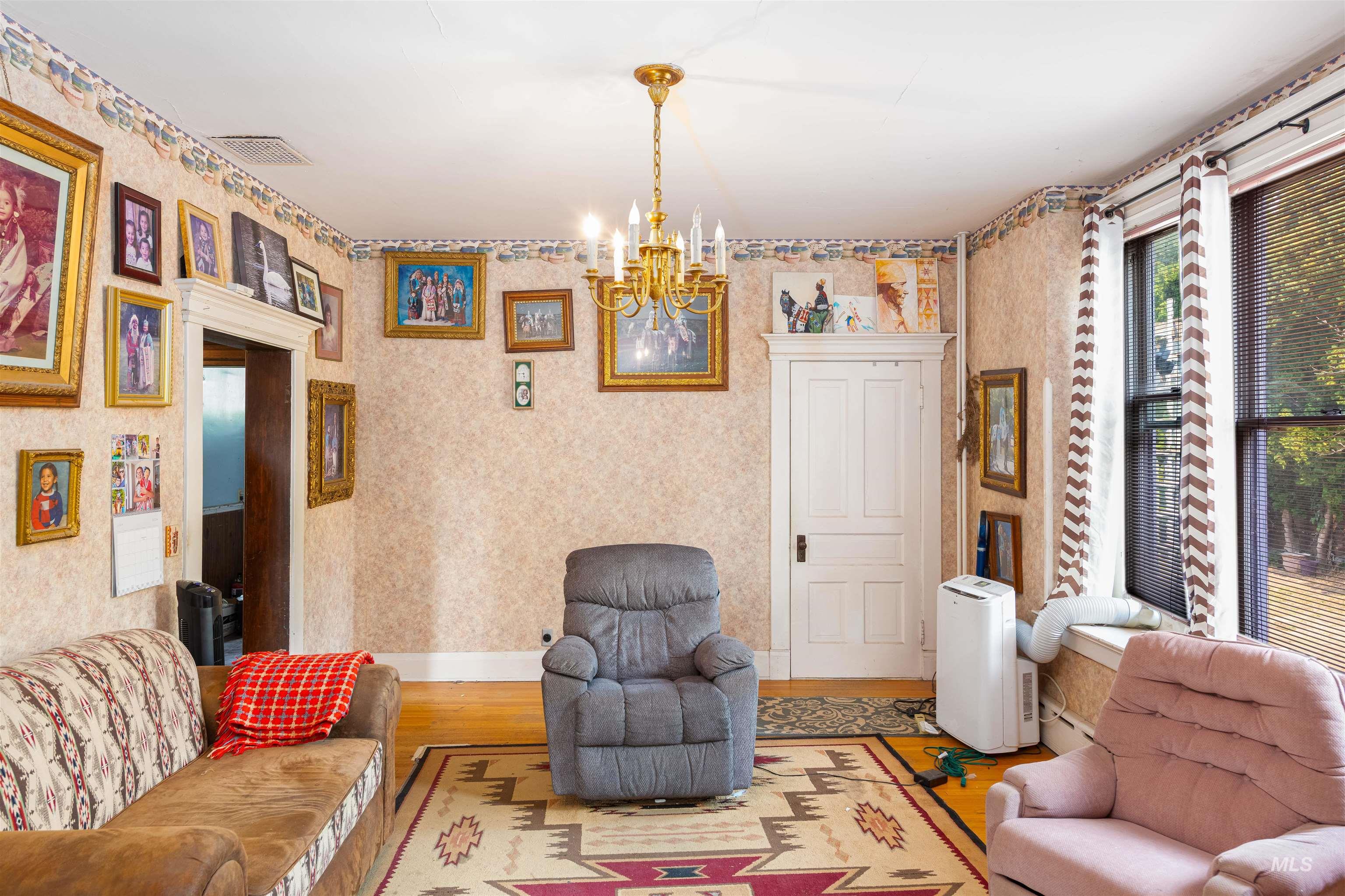 507 7th Avenue Lewiston, ID 83501 - Photo 11 of 30 Living room with a chandelier, wood finished floors, and a baseboard radiator