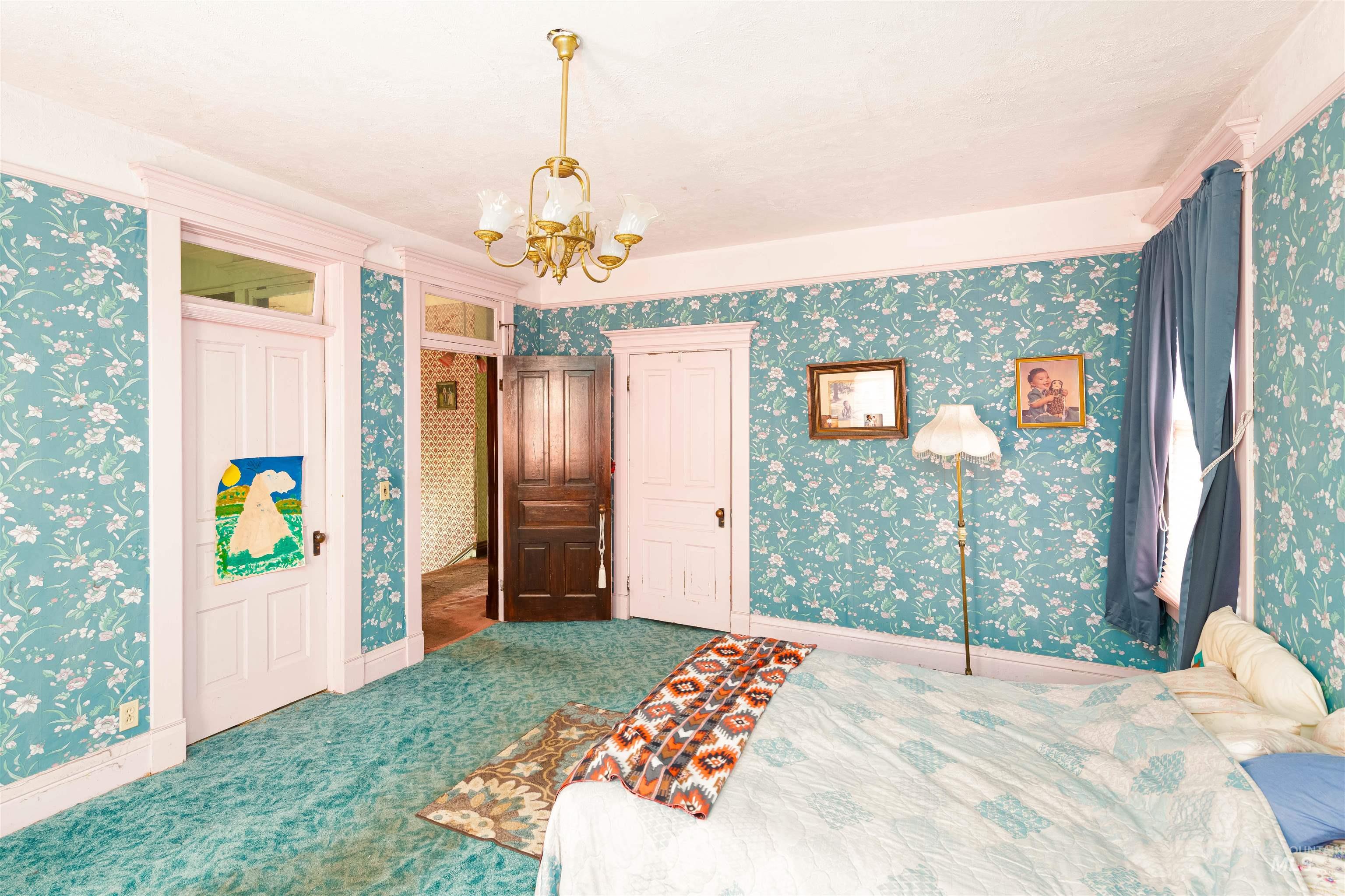 507 7th Avenue Lewiston, ID 83501 - Photo 24 of 30 Carpeted bedroom featuring wallpapered walls, a chandelier, and a closet