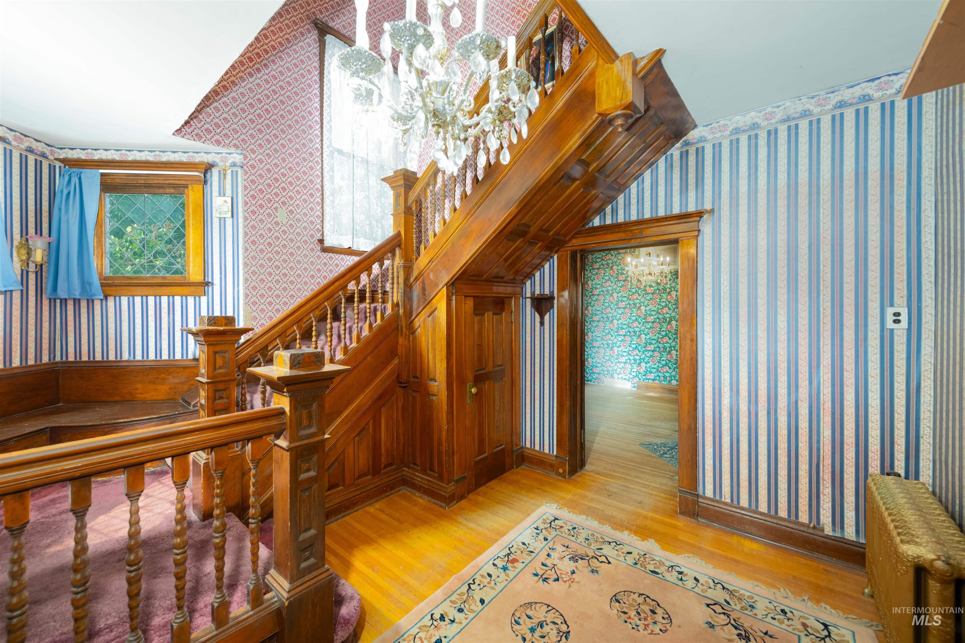 507 7th Avenue Lewiston, ID 83501 - Photo 6 of 30 Staircase with wallpapered walls, wood finished floors, and radiator heating unit