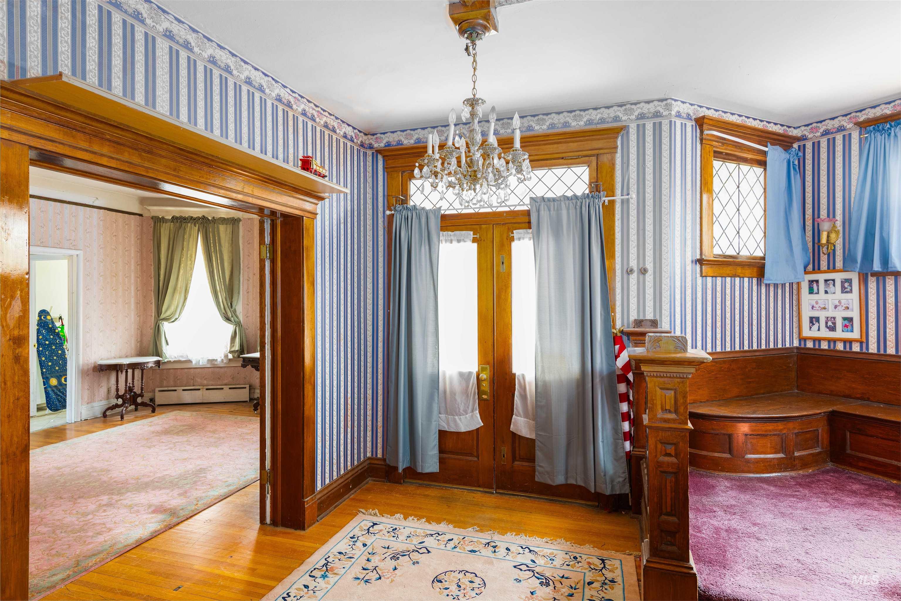507 7th Avenue Lewiston, ID 83501 - Photo 7 of 30 Foyer with wallpapered walls, light wood-style flooring, a chandelier, french doors, and a baseboard heating unit