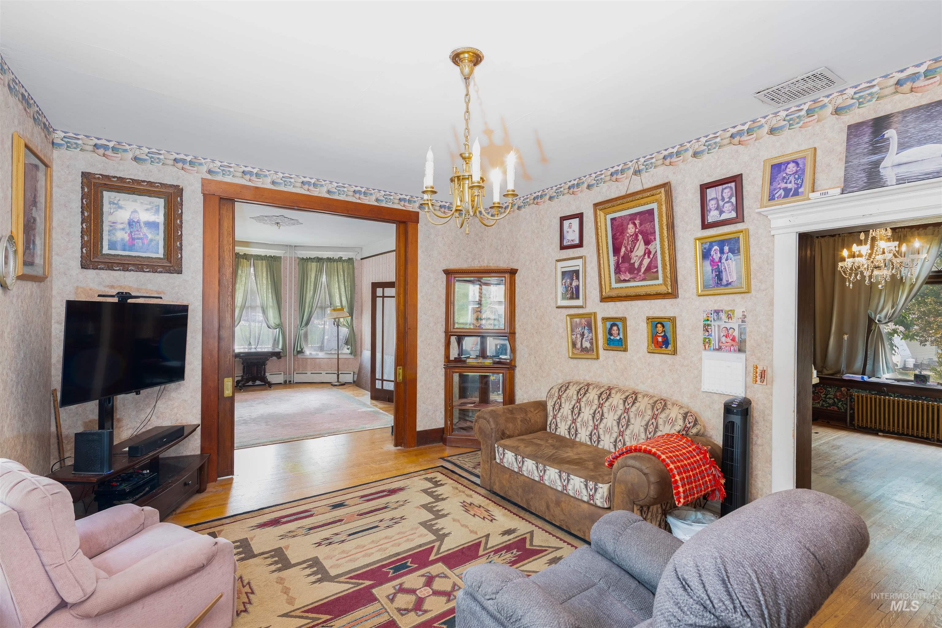 507 7th Avenue Lewiston, ID 83501 - Photo 9 of 30 Living area with a chandelier, wood finished floors, and radiator heating unit