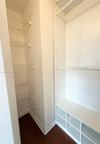 a view of walk in closet with empty racks