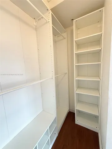 a view of walk in closet with empty racks