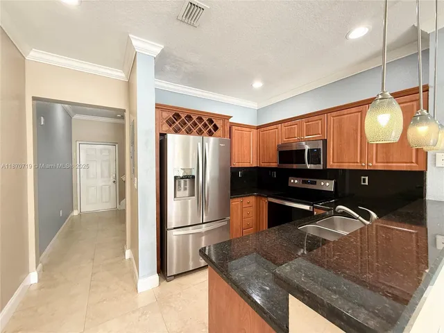 a kitchen with stainless steel appliances granite countertop a sink a stove and a refrigerator
