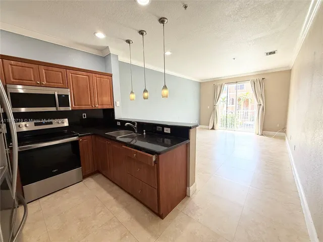 a kitchen with stainless steel appliances granite countertop a stove a sink and a microwave