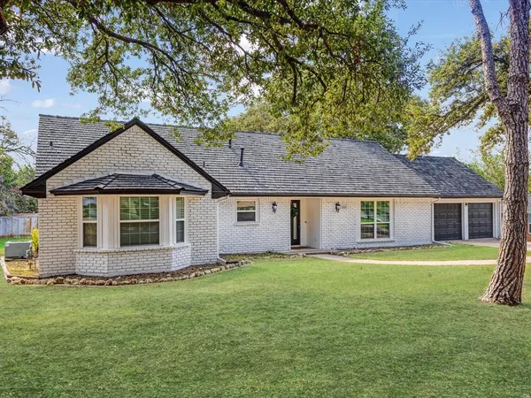 a front view of house with yard and trees in the background