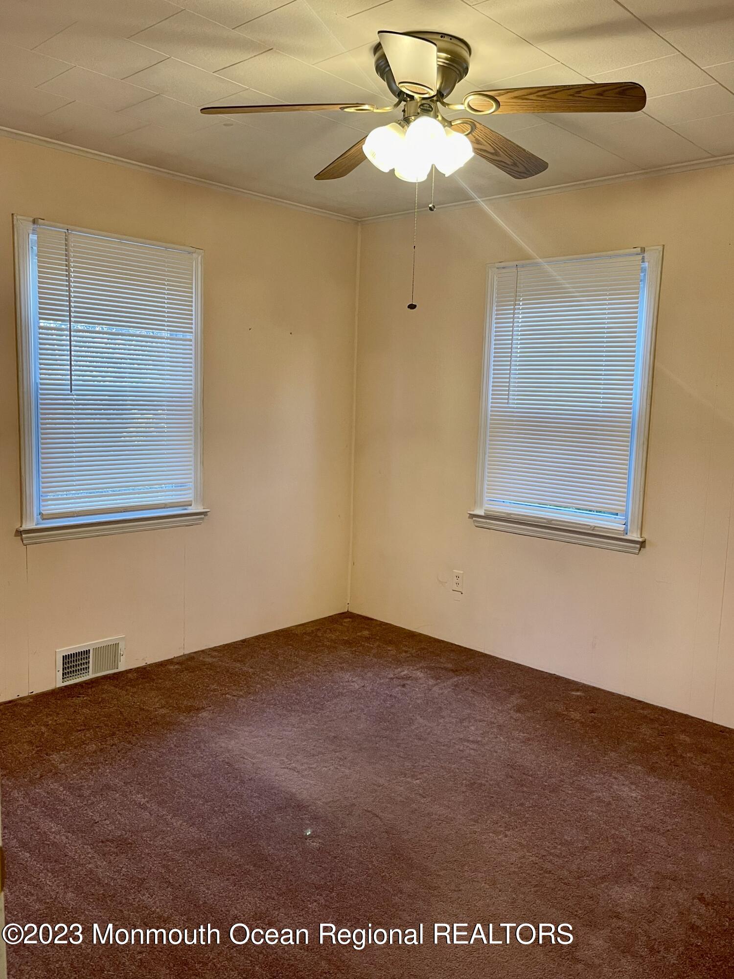 53 Crestview Drive Middletown, NJ 07748 - Photo 18 of 21 an empty room with a chandelier fan and wooden floor