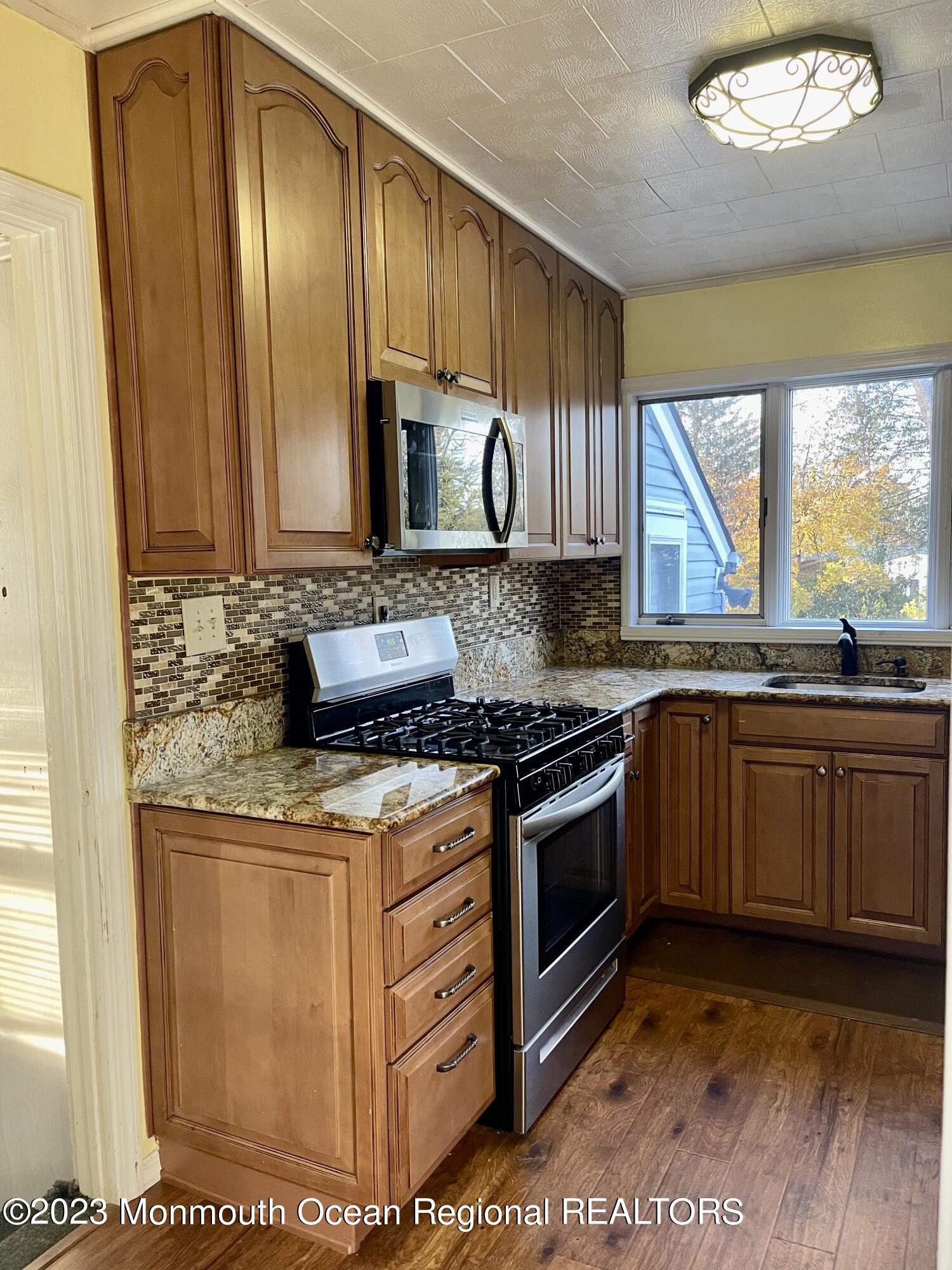 53 Crestview Drive Middletown, NJ 07748 - Photo 5 of 21 a kitchen with stainless steel appliances granite countertop a stove a sink and a microwave