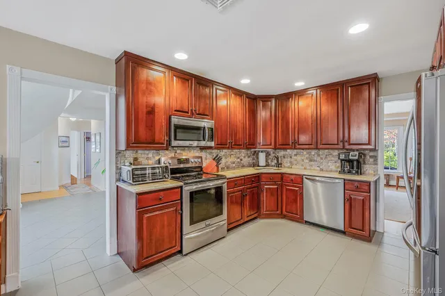 a kitchen with stainless steel appliances granite countertop wooden cabinets a stove top oven a sink and dishwasher