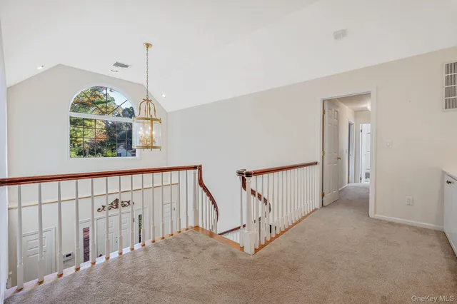 a view of staircase with railing and a chandelier