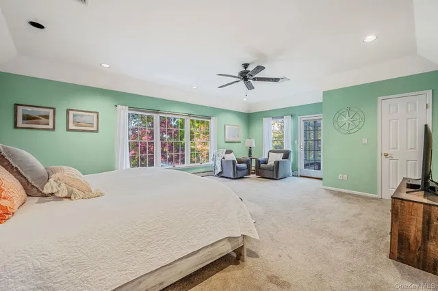 a bed room with a bed mirror furniture and a flat screen tv