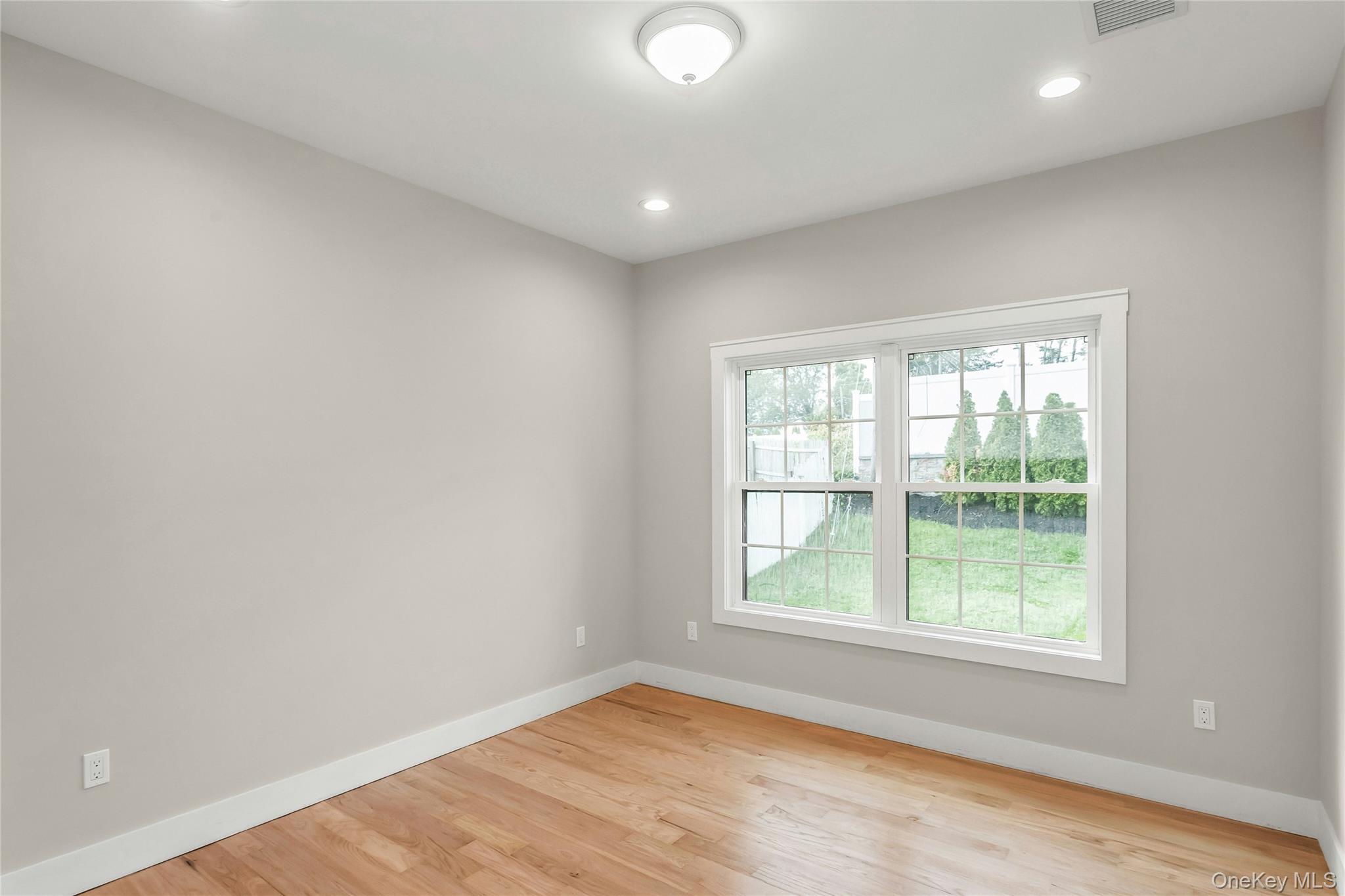 8 Sebree Place Plainview, NY 11803 - Photo 13 of 26 Unfurnished room with light wood-style flooring and recessed lighting