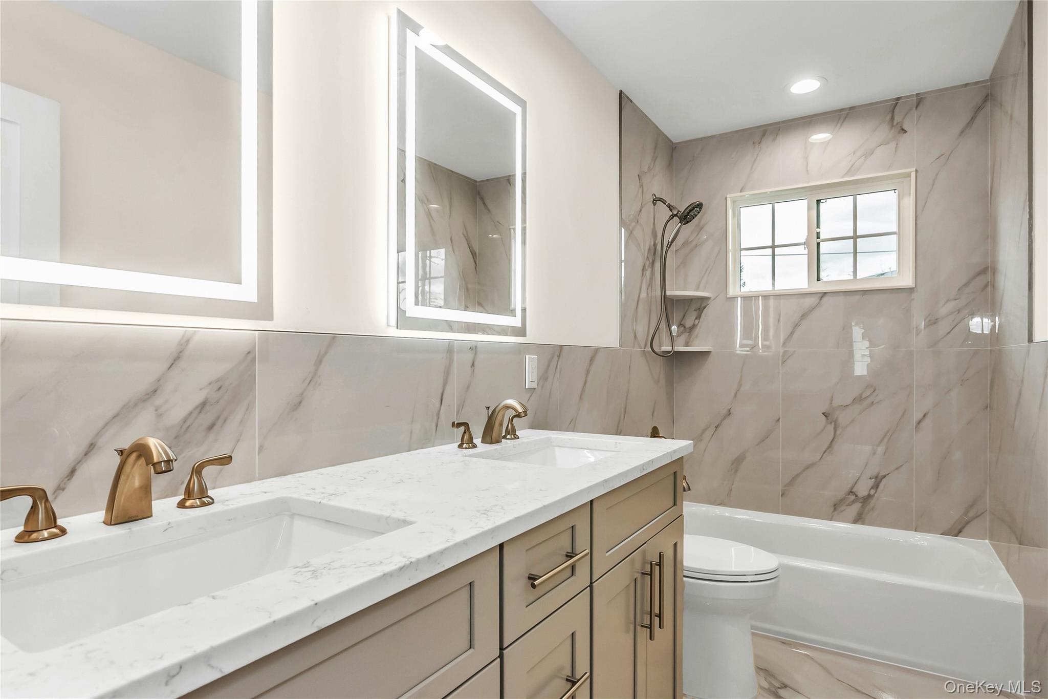 8 Sebree Place Plainview, NY 11803 - Photo 22 of 26 Bathroom with tile walls, double vanity, a combined bath / shower with marble appearance, and backsplash