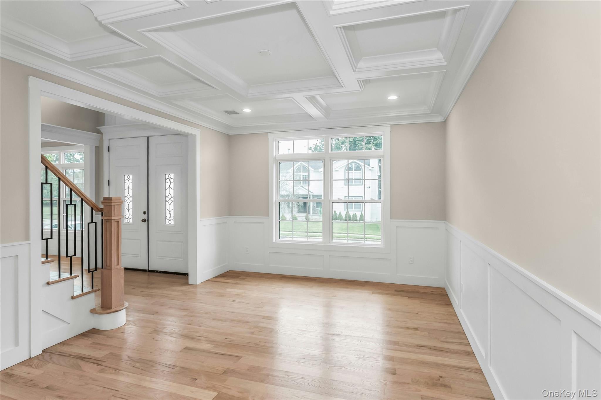 8 Sebree Place Plainview, NY 11803 - Photo 5 of 26 Entrance foyer featuring healthy amount of natural light, stairs, beam ceiling, light wood-style floors, and coffered ceiling