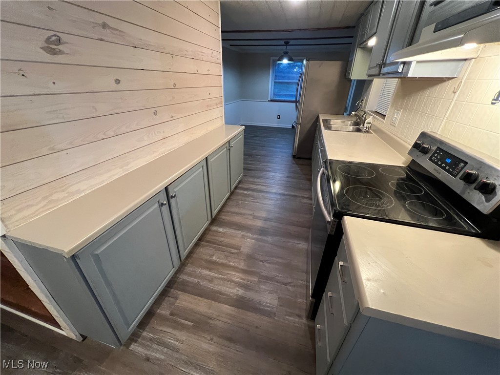 280 Holly Road Northwest Dellroy, OH 44620 - Photo 10 of 26 Kitchen featuring appliances with stainless steel finishes, decorative backsplash, exhaust hood, dark hardwood / wood-style floors, and sink