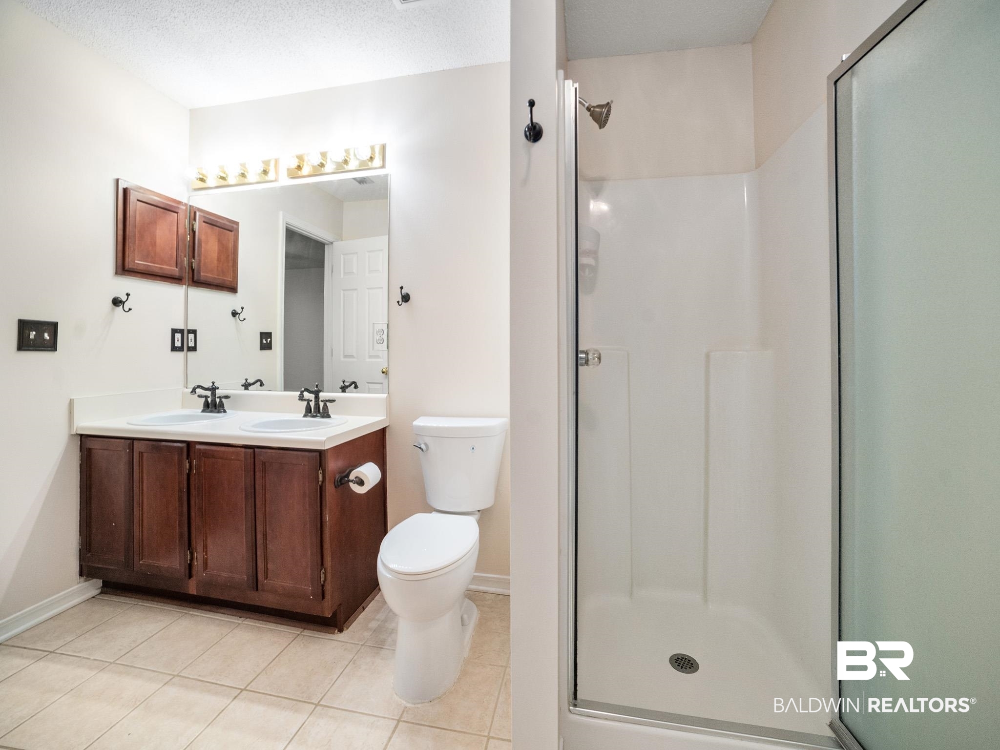 8320 Milton Road Mobile, AL 36695 - Photo 21 of 27 Bathroom with tile patterned floors, vanity, a textured ceiling, an enclosed shower, and toilet